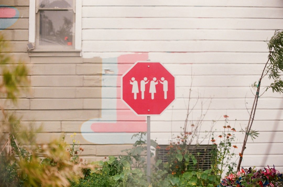 Single parent with children looking at a suburban home with a for sale sign
